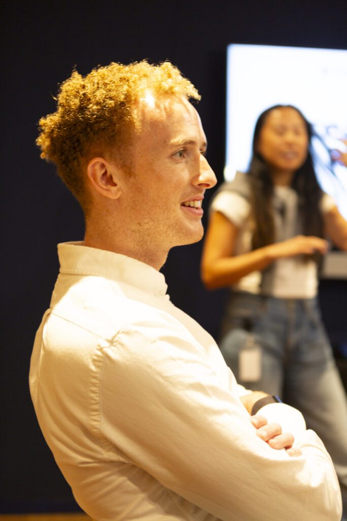 Jamie Cook, US MD, is sitting with his arms crossed. The photo is taken from side-on